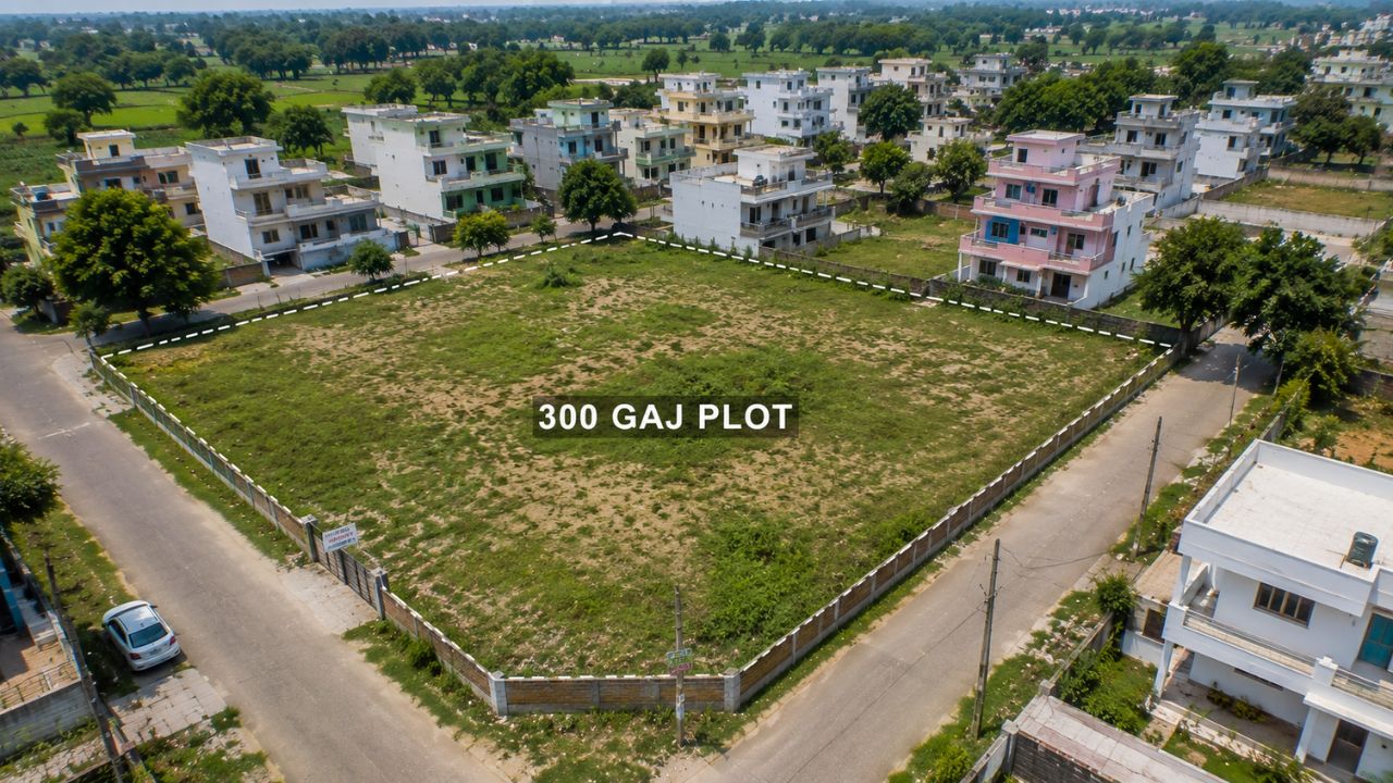 Aerial view of a 300 Gaj residential corner plot in Rudrapur surrounded by developed houses, internal roads, and green surroundings.