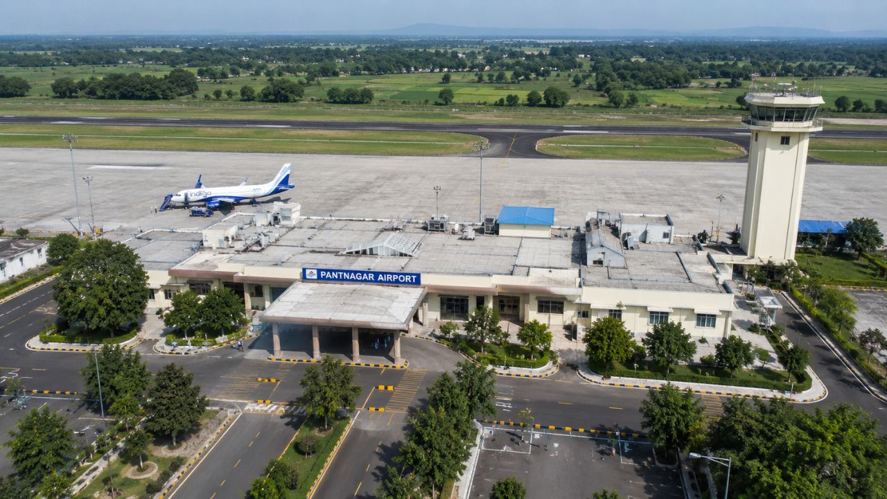 Aerial view of Pantnagar Airport in Uttarakhand showing the terminal building, runway, control tower, and aircraft, highlighting airport expansion and its impact on Rudrapur real estate.