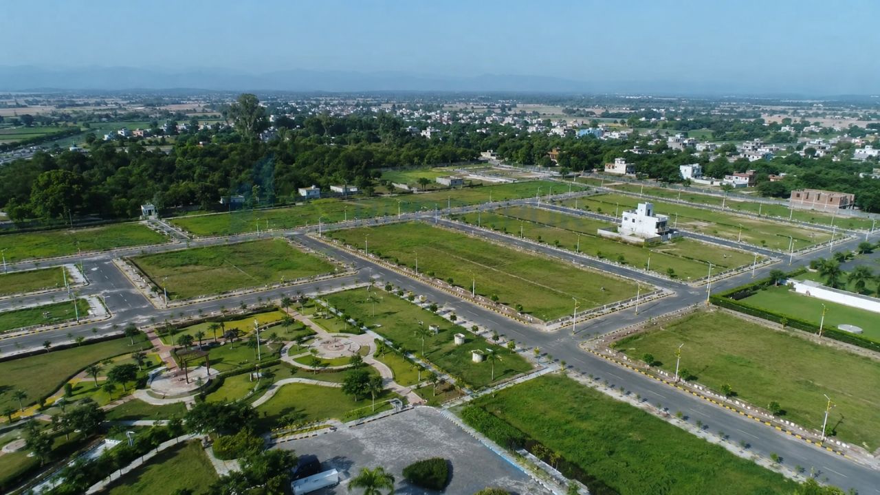 Aerial view of a plotted residential township with roads, green parks, and available plots for sale in Rudrapur, Uttarakhand.