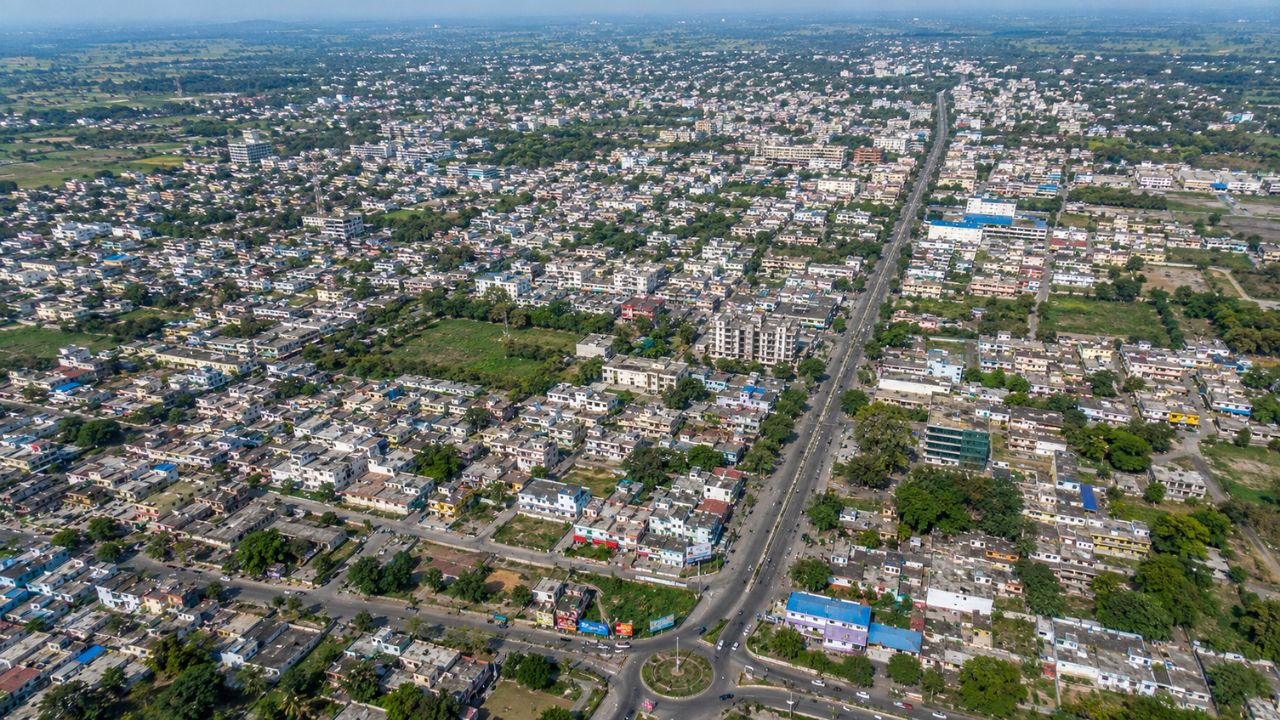 Aerial view of Rudrapur city in Uttarakhand showing residential neighborhoods, commercial roads, and urban development representing plot prices and real estate growth.