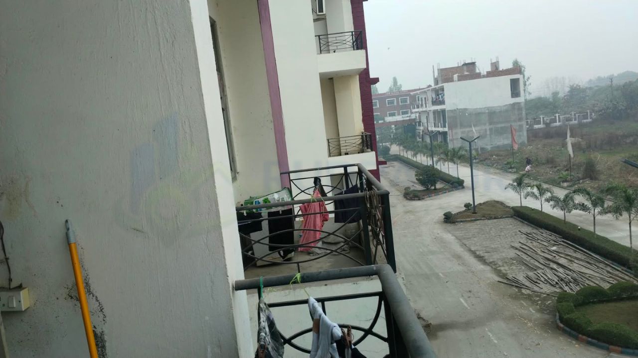Balcony view of affordable 3BHK flat in Danpur Rudrapur with society road and landscaped surroundings
