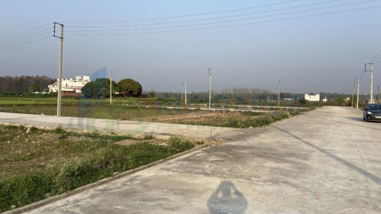 Residential plots in Jainagar Rudrapur along Dineshpur Road with developed concrete roads, electricity poles and open surroundings
