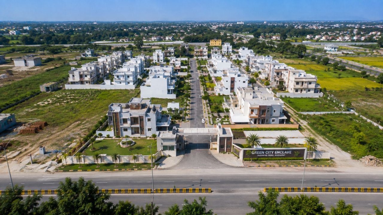 Aerial view of a residential development in Rudrapur with plots, modern homes, landscaped roads, and surrounding open land